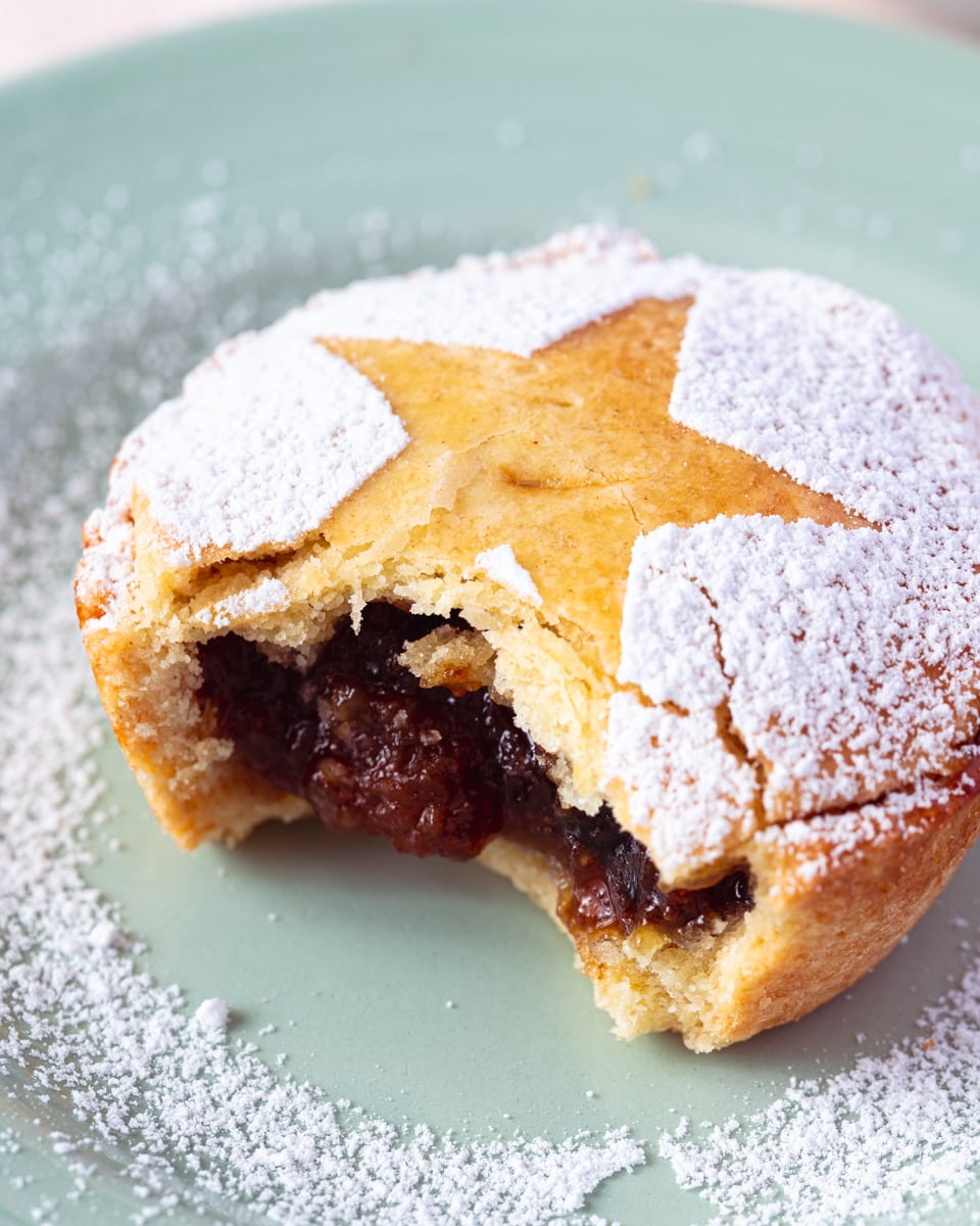 Close up on a mince pie with a large bite taken out. 