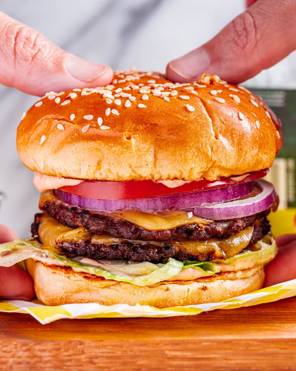 hands holding a Vegan Smash Burger