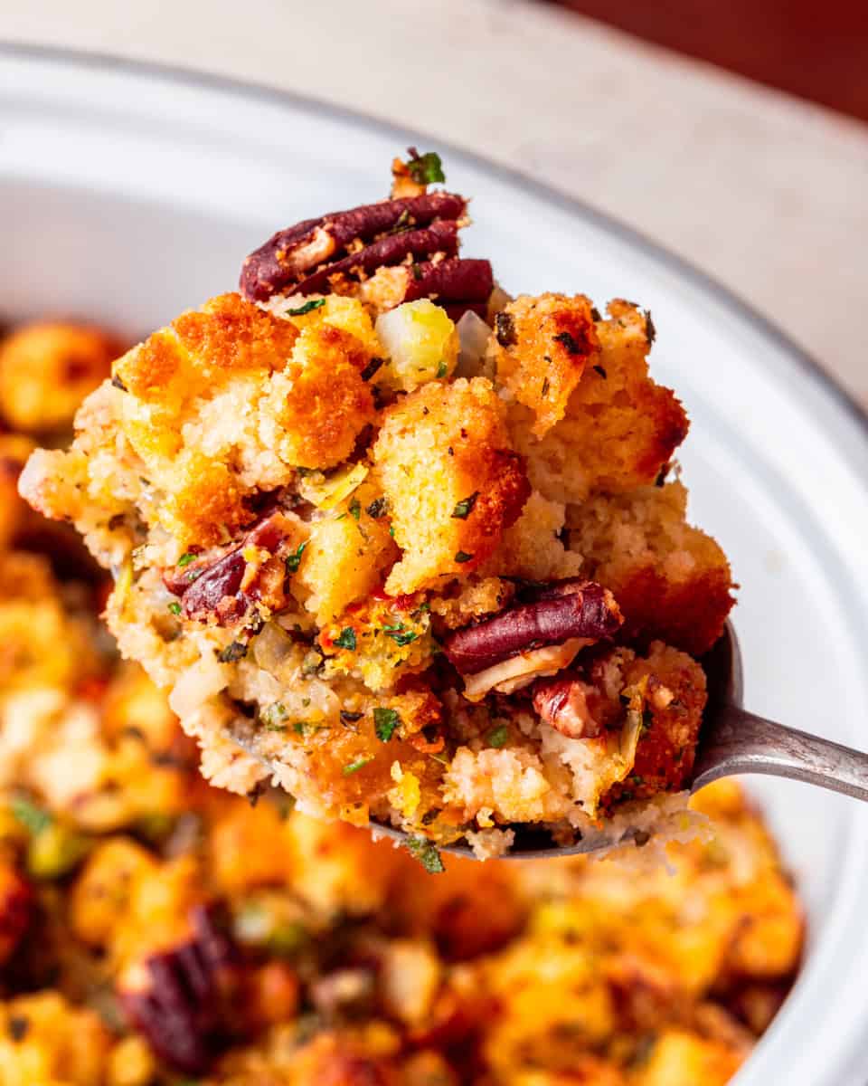 a silver spoon holding a portion of vegan cornbread stuffing