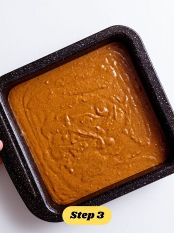 Step 3 of the vegan pumpkin sticky toffee pudding method: The batter for the pudding in a black brownie tin.