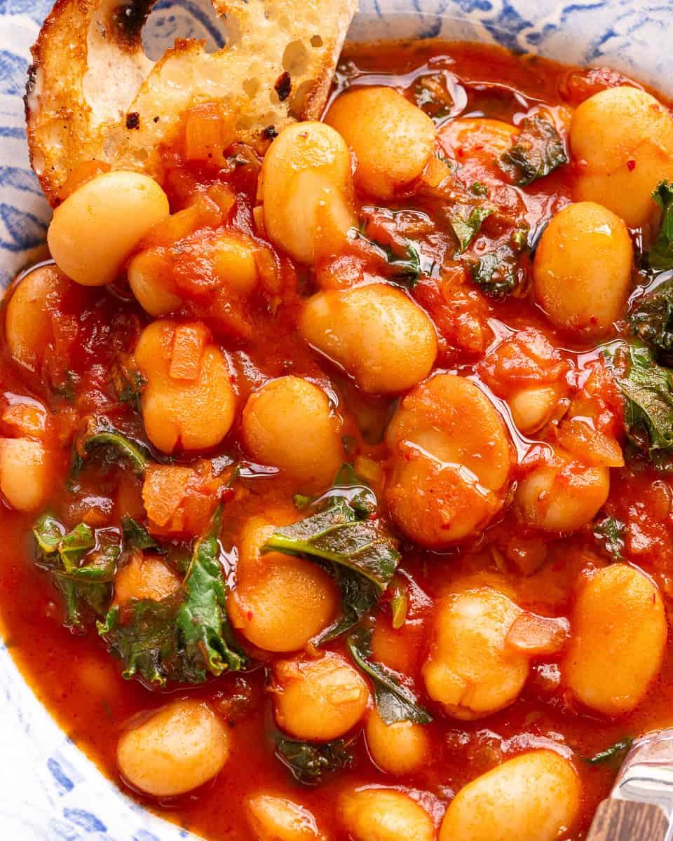 A bowl of butter bean stew with a piece of crusty bread